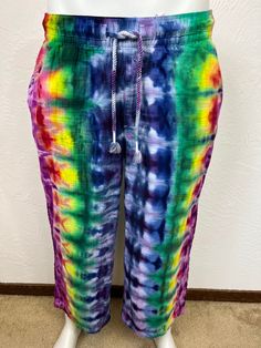 Ice tie dye large sized women's soft pants. High-waisted pants sit at belly button. Relaxed through the hip and thigh. Wide leg, and will hit above the ankle. Elasticized waistband with drawstring fastening. On-seam diagonal side pockets and back patch pockets. Made from 100% textured cotton, is machine wash cold with dark colors, machine dry low. Super comfy, great for festivals or just hangin out at home! Measurements are garment laid out flat  17 inches from waist edge to edge at top 12 inches from top of waistline to crotch  24 inch inseam  22 inches side to side at hips Comfortable Drawstring Pants, Summer Beach Parachute Pants With Relaxed Fit, Relaxed Fit Parachute Pants With Elastic Waistband For Beach, Relaxed Fit Bottoms With Elastic Waistband And Tie Sides, Relaxed Fit Tie-side Bottoms With Elastic Waistband, Hippie Trousers For Loungewear, Hippie Style Trousers For Loungewear, Hippie Loungewear Trousers, Stretch Cotton Harem Pants For Vacation