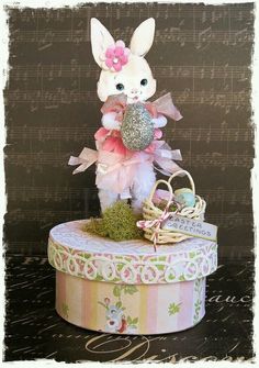 a small white rabbit sitting on top of a box filled with musical notes and decorations