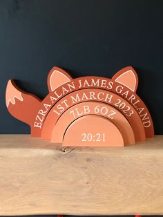 a wooden shelf with three plates on it and a name plate attached to the top