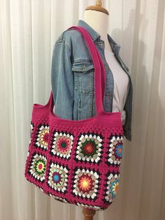 a pink crocheted purse sitting on top of a mannequin