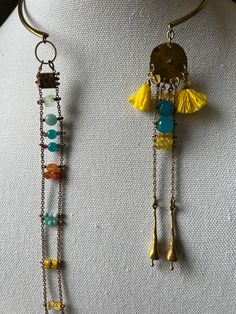 The upper part, a solid piece of brass is the choker part from which two separate medallions are suspended. One has a ladder like effect with stone beads replacing the ladder rungs. The second starts with a tasseled accent with chains suspended from it with some intermittent rungs. Handmade Fusion Long Drop Jewelry, Bohemian Double Strand Necklace With Dangling Beads, One Of A Kind Brass Dangle Jewelry, Artisan Beaded Chain Dangle Jewelry, Artisan Multi-strand Beaded Chain Jewelry, Metal Long Necklace With Dangling Beads, Artisan Dangle Beaded Chain Jewelry, Handmade Double Strand Metal Jewelry, Long Metal Necklace With Dangling Beads