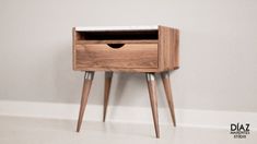 a small wooden table with two drawers on it