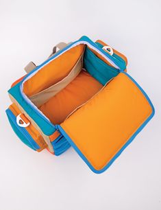 an open blue and orange suitcase on a white surface with the lid opened to show it's inner compartment