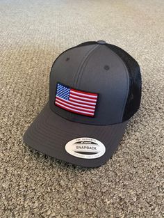 a gray and black hat with an american flag patch