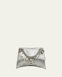 Balenciaga "Crush" shoulder bag in metallic leather     Sliding chain shoulder strap with charms     Flap top with magnetic closure     Interior, one zip pocket     Approx. 5.9"H x 9.8"W x 3.1"D    Made in Italy Small Charms, Metallic Leather, Magnetic Closure, Leather Shoulder Bag, Balenciaga, Zip Pockets, Tops Designs, Shoulder Strap, In Italy