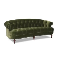 a green velvet couch with wooden legs and nail polishing on the armrests