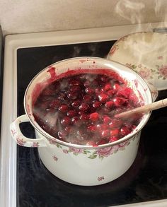 a pot filled with cranberry sauce on top of a stove