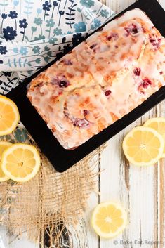 a loaf of lemon blueberry bread on top of a table with sliced lemons