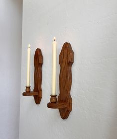 two wooden candles are on the wall next to each other