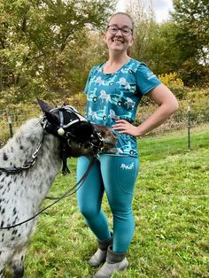 a woman standing next to a small horse