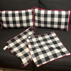 three black and white checkered pillows sitting on top of a couch next to each other