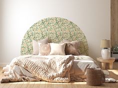 a bed with pillows and blankets on top of it in front of a white wall