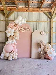 balloons and flowers are arranged in front of a large sign that reads,'alya '