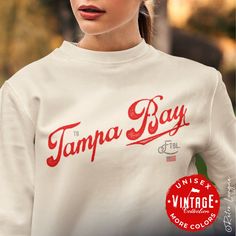 This Tampa Bay Buccaneers Crewneck Sweatshirt would make the perfect gift for your diehard Tampa Bay football fan.  This vintage collection features a Tampa Bay retro style typography design and team colors USA flag.  Perfect birthday, Christmas or anytime gift for the hardcore Tampa Bay football fan in your life! Ideal for any situation, a unisex heavy blend crewneck sweatshirt is pure comfort. These garments are made from polyester and cotton. This combination helps designs come out looking fresh and beautiful. The collar is ribbed knit, so it retains its shape even after washing. * 50% cotton, 50% polyester * Medium-heavy fabric (8.0 oz/yd² (271.25 g/m²) * Loose fit * Sewn-in label * Runs true to size * Tear away label * Color of products may appear different on various monitors * Machi Crew Neck Tops With Lettering For Fan Gear, Crew Neck Tops With Lettering For Fans, Fan Merchandise Crew Neck Top With Lettering, Crew Neck Tops With Lettering For Fan Merchandise, Fan Merchandise Tops With Lettering, Fan Merchandise Lettering Tops, Football Sweatshirt, Tampa Bay Buccaneers, Retro Stil