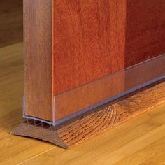 a close up view of a wooden floor with a metal strip on the bottom edge