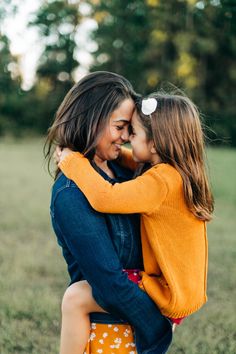 two girls hugging each other in the grass