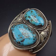 "VINTAGE NAVAJO BRACELET DESCRIPTION: This cuff features a pair of gorgeous Blue Diamond turquoise cabochons. The gemstones are secure in smooth bezel, on a foundation of heavy gauge vintage sterling silver. This bracelet will be a cherished addition to your collection of fine vintage Native American jewelry. MEASUREMENTS: Interior of the cuff measures 5 3/8\" with an additional 1 3/8\" slightly adjustable gap. Total circumference: 6 3/4\" Measures 2 3/8\" straight across the widest part of the Southwestern Blue Cuff Jewelry, Turquoise Bangle Cuff Bracelet For Formal Occasions, Luxury Blue Cuff Jewelry, Blue Oval Gemstone Cuff Bracelet, Formal Blue Bracelets With Cabochon, Classic Blue Bangle For Formal Occasions, Blue Classic Bangle For Formal Occasions, Formal Blue Gemstone Cuff Bracelet, Blue Round Cuff Bracelet For Formal Occasions