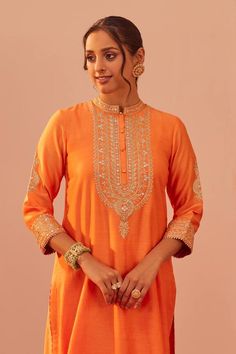 Tangerine orange long straight kurta with tilla, patra, mirror, zari thread embroidered yoke. Paired with palazzo and floral hand block print dupatta.
Components: 3
Pattern: Embroidery
Type Of Work: Tilla, patra, mirror, zari thread
Neckline: Band collar
Sleeve Type: Three quarter
Fabric: Kurta and Palazzo: Silk Chanderi, Dupatta: Silk Organza
Color: Orange
Other Details: 
Front embellished buttons
Cutwork border
Sheer printed dupatta
Scallop border on palazzo hem
Occasion: Mehendi and Haldi - A Semi-stitched Orange Chikankari Traditional Wear, Orange Chikankari Embroidery Sharara For Navratri, Orange Chikankari Embroidered Sharara For Navratri, Orange Sharara With Intricate Embroidery For Diwali, Orange Bollywood Kurta For Transitional Season, Orange Saree Set With Intricate Embroidery, Diwali Orange Sharara With Intricate Embroidery, Orange Sharara For Wedding, Elegant Orange Sharara For Eid