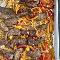 a tray filled with meat and peppers on top of a table