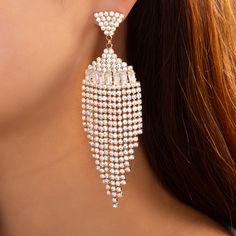 a close up of a woman's ear wearing large earrings with pearls on them