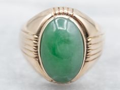 Simple but stylish, this is a classic piece, with a simple structural design. The center stone is subtle, well-polished jade in a domed cabochon cut, bezel set for safety and security. The apple green color is a nice compliment to the warm tone of the gold. Metal: 14K Yellow GoldGem: JadeGem Measurements: 15.1 x 9.9 mm, OvalRing Size: 12Marks: "14K" Stamped on the inside band Formal Green Cabochon Emerald Ring, Green Emerald Ring With Oval Cabochon Bezel Setting, Modern Oval Green Jewelry, Formal Oval Jade Emerald Ring, Classic Green Band Jewelry, Classic Domed Emerald Ring For Formal Occasions, Modern Green Round Band Jewelry, Formal Green Emerald Ring With Polished Finish, Modern Oval Jade Jewelry