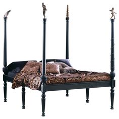 a bed with four posts and an animal print comforter on the bottom, along with two small figurines