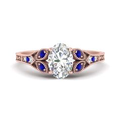 a diamond and blue sapphire engagement ring with an oval center stone in rose gold setting