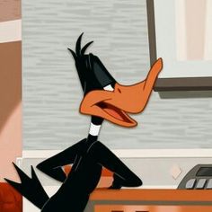 a cartoon character sitting at a desk with his feet on the table and one leg up