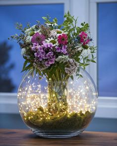 a vase filled with lots of flowers on top of a table