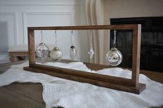 a wooden frame with ornaments hanging from it's sides in front of a fireplace