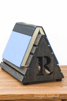 a wooden block with a book on top of it and the letter r next to it