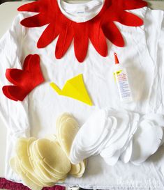 a white shirt with red and yellow felt flowers on it, along with other crafting supplies