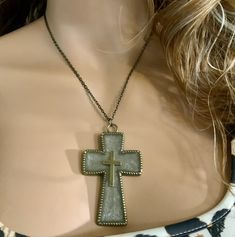 a woman wearing a necklace with a cross on it