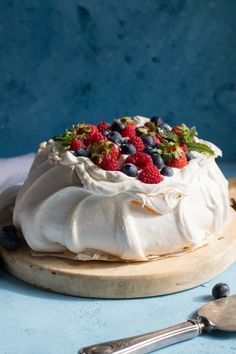 the best pavlova recipe with fresh berries and blueberries in it on a cutting board