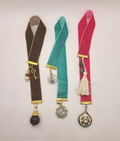 three different colored lanyards with charms on them