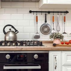 a stove top oven sitting inside of a kitchen next to a pot and spatula