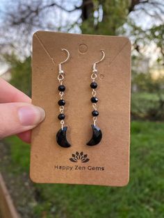 This listing is for one pair of Dainty, Black Onyx Moon Dangle earrings. Please note that the Black Onyx crescent moons are genuine, but the remaining stones are faux. Each pair of earrings are made to order, just for you!  ･ ｡ﾟ☆: *.☽ .* :☆ﾟ. Black onyx is the stone of protection, strength, and willpower. Onyx is an excellent stone in providing one with the ability to pursue their goals and dreams but also protects its wearer along the way. Wearing Onyx provides its wearer with a protective shield, deflecting any negative energy that may come your way.  ･ ｡ﾟ☆: *.☽ .* :☆ﾟ. ☆Care instructions☆ We highly recommend avoiding water and direct sunlight, as prolonged exposure to either can cause the silver and copper to tarnish. ☽Thank you for visiting Happy Zen Gems☆ Black Moon Charm Jewelry For Party, Black Jewelry With Moon Charm For Party, Black Dangle Plug Earrings As Gift, Black Dangle Plug Earrings For Gift, Nickel-free Black Plug Earrings As Gift, Handmade Black Moon-shaped Earrings, Black Moon Shaped Earrings For Gift, Black Moon-shaped Earrings For Gift, Handmade Black Moon Earrings