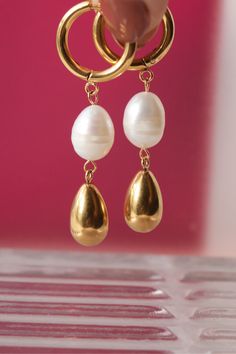 Get ready for some serious sparkle with these golden dangling earrings featuring freshwater pearls Product Details Size: 5 cm length / .8 cm width 18K Gold Plated Stainless Steel Water-Resistant HypoallergenicDurable Gold Pearl Drop Dangle Earrings, Gold Dangle Earrings With Pearl Drop, Gold Dangle Pearl Earrings With Pearl Chain, Gold Pearl Chain Dangle Earrings, Gold Pearl Teardrop Dangle Earrings, Gold Pearl Teardrop Earrings With Pearl Drop, Gold Teardrop Pearl Earrings With Pearl Charm, Metal Dangle Earrings With Pearl Pendant, Gold Teardrop Earrings With Pearl Charm