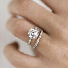 a woman's hand with two rings and a diamond ring on her left hand