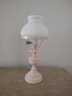 a pink lamp sitting on top of a wooden table