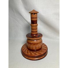 a small wooden lighthouse on top of a stand