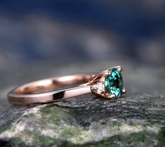 a close up of a ring with a stone in the middle on top of a rock