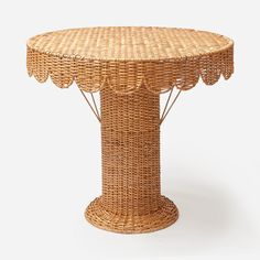 a wicker table with scalloped edges on the top and an oval base