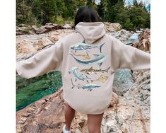 This shark hoodie will keep you cozy on cool, windy nights. It features common sharks such as the massive whale shark, great white shark, hammerhead shark, and more! Any shark lover would love this! ➡️ Design is printed on back of hoodie. The front is blank ⬅️ 🤩 TIP: These run true to size. If you want an oversized look, size up 1-2 sizes. 😉 ✅ Information: ★ Gildan Unisex Hoodie ★ -50% Cotton 50% Polyester -Medium-heavy fabric -Classic fit -Tear away label -Runs true to size ✅Design Printing D Back Print Hoodie, Back Of Hoodie, Hawaii Hoodie, Save The Sharks, Dolphin Gifts, Hoodie Back, Dolphin Lover, Beach Hoodie, Shark Hoodie