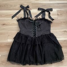 a black dress with lace and bows on it