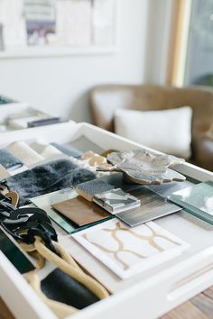 the table is covered with many different types of art materials and papers, including scissors