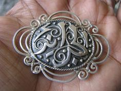 An antique sterling silver Arabic Ottoman Islamic brooch. It has a lovely traditionally detailed center with a nice scalloped border. The brooch measures 2'' x 1 1/2''. There are 3 marks on the back of the brooch that can not be recognized, however, it has been tested and found to be solid sterling silver. It weighs 9.2 grams. Classic Silver Brooches With Intricate Design, Traditional Engraved Brooches For Gift, Traditional Hallmarked Brooches For Anniversary, Oval Brooch With Intricate Design As A Gift, Intricate Oval Brooch As Gift, Ornate Antique Silver Brooch As Gift, Ornate Antique Silver Brooch For Gift, Silver Medallion Brooches As A Gift, Traditional Silver Brooches For Anniversary