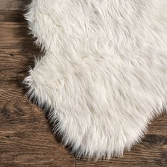 a white rug on top of a wooden floor next to a wood flooring board