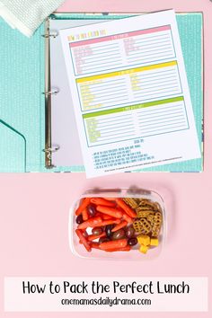 a lunch box filled with carrots and other food items on top of a pink table