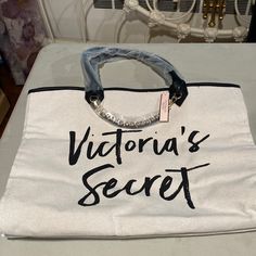 A Beautiful Brand New Victoria Secret Beach Bag With Tag In Off White And Handles In Black With A Chain In Front For A Nice Touch. It’s Length Is 16 Inches By Width About 6 Inches And Height 12 3/4 Inches. A Zipper Compartment Inside Of The Bag. White Rectangular Victoria's Secret Bag, Trendy Victoria's Secret Vacation Bag, Victoria's Secret White Bag For Beach, Victoria Secret Beach, Victoria's Secret Beach Bag For Summer, Victoria's Secret Summer Vacation Bags, Chic Victoria's Secret Beach Bag, Victoria's Secret White Beach Bag, Victoria's Secret Casual Beach Bag